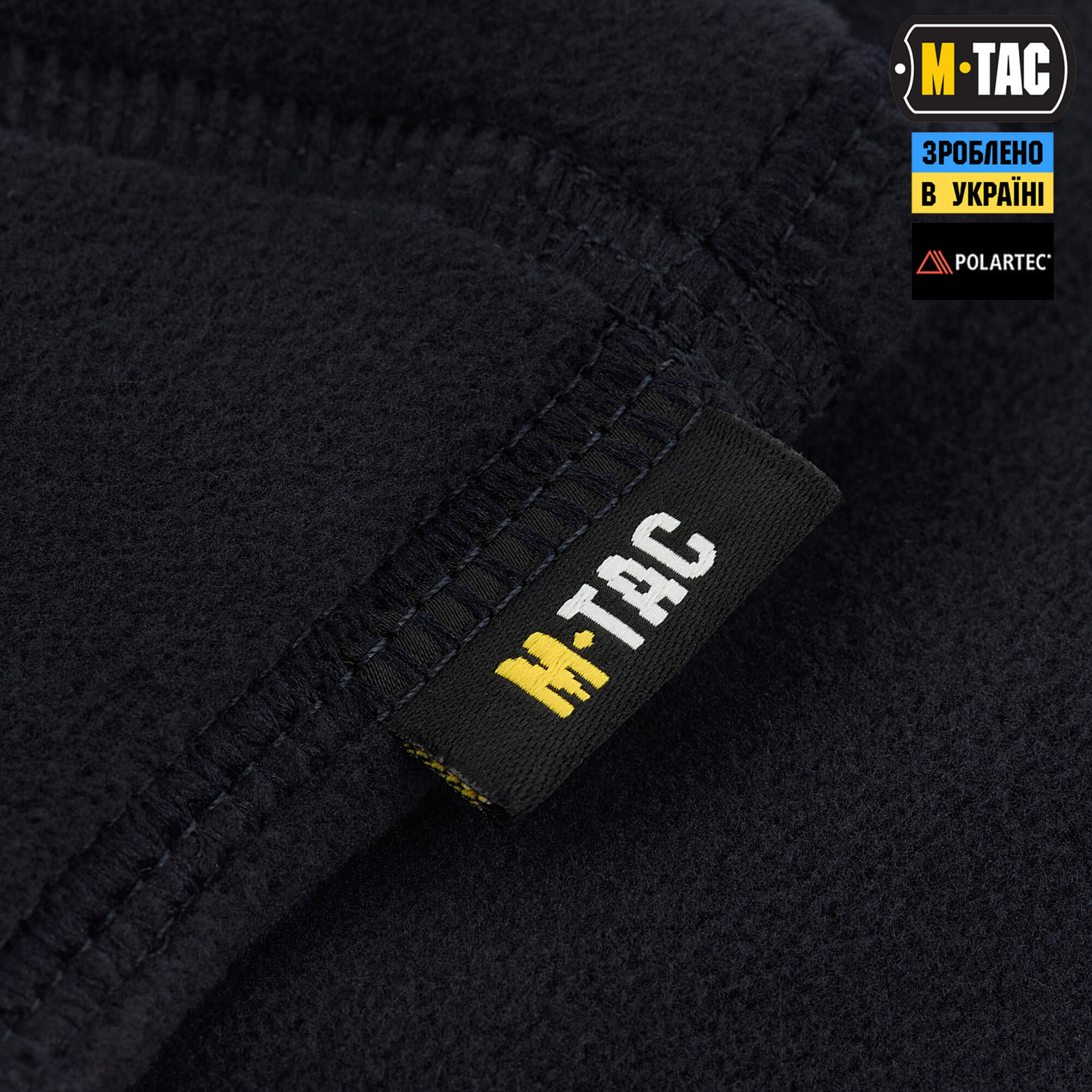 Close-up of a black fleece jacket with M-Tac branding and Polartec logo.