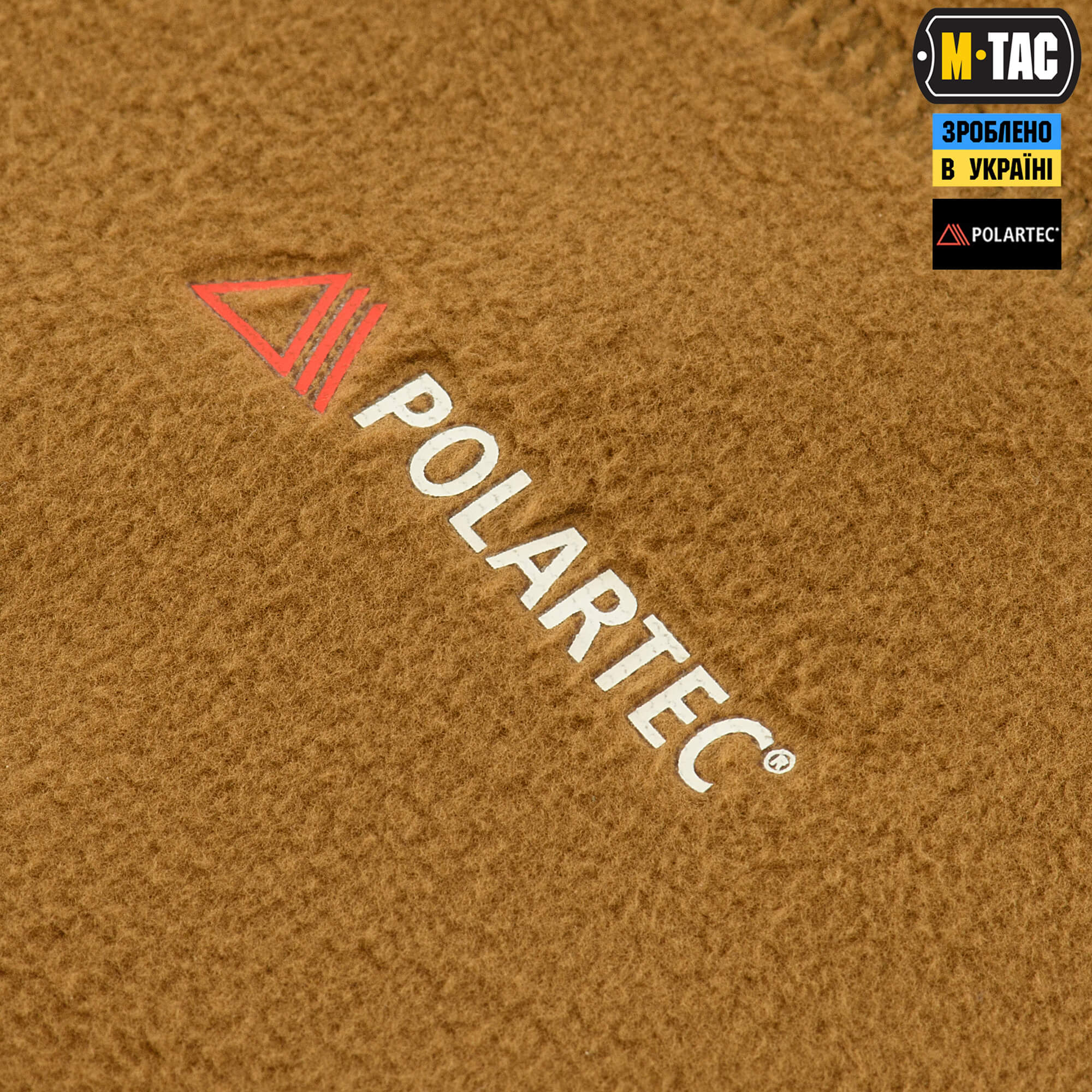 Close-up of Polartec logo on brown fabric with M-Tac branding.