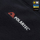 Close-up of a black fabric with Polartec logo and branding elements.
